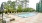 swimming pool with lounge chairs and trees in the background