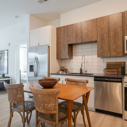 Beautiful kitchens with designer finishes kitchen with stainless steel appliances and a table with chairs