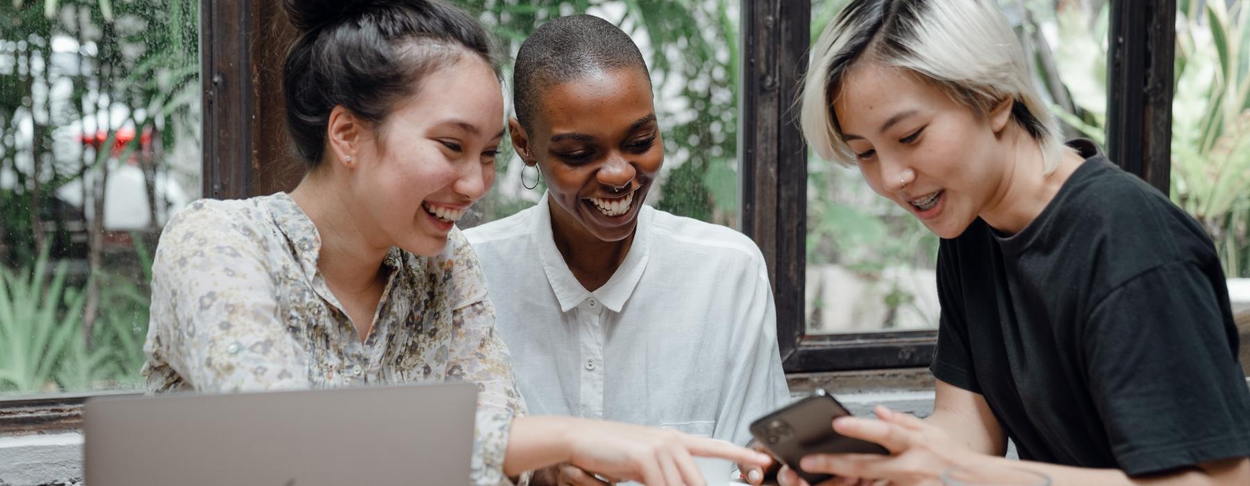 a group of people looking at a laptop